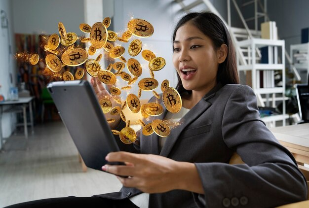 Woman using a tablet with cryptocurrency coins emerging