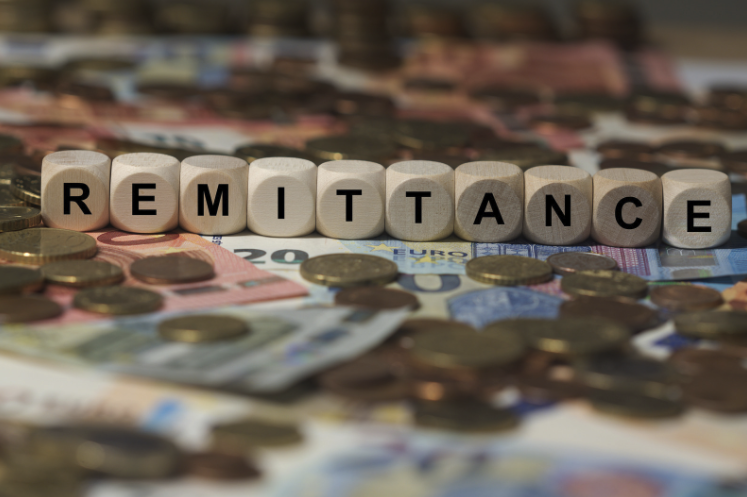 Wooden cubes spelling “remittance”